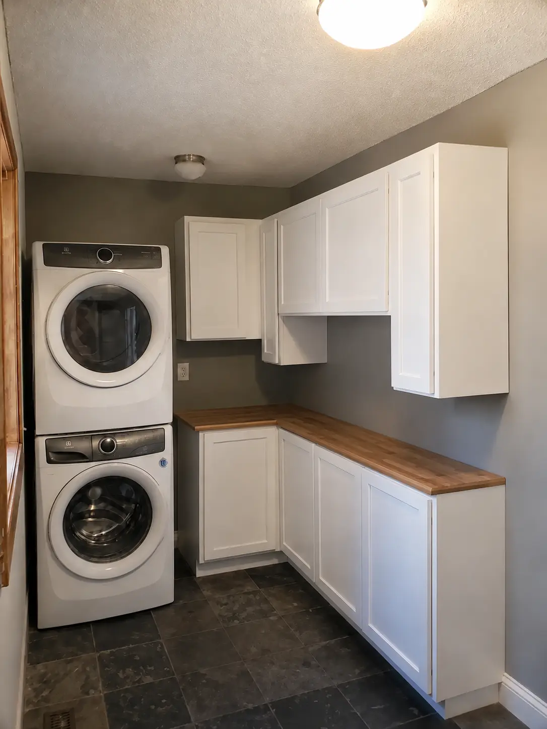 Custom laundry room cabinetry with butcher-block counter