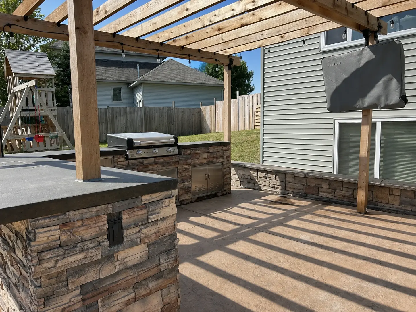 Custom outdoor kitchen with stacked-stone island, built-in grill and counters